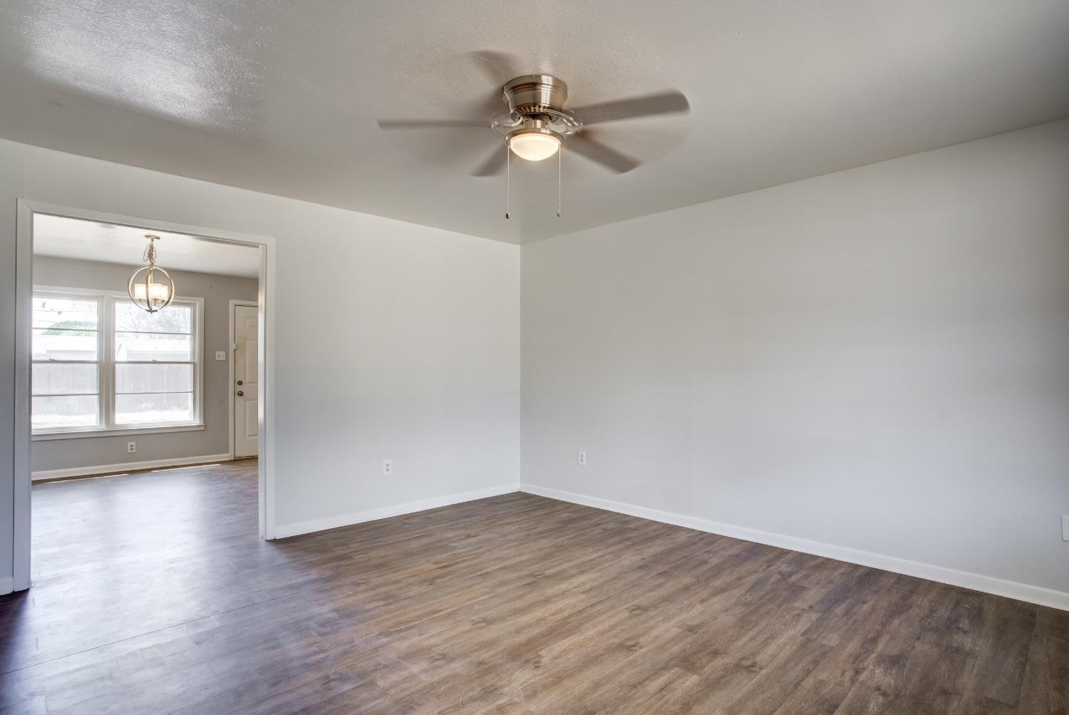 3011 44th Street Lubbock, TX 79413 - Photo 5 of 19 an empty room with wooden floor and windows
