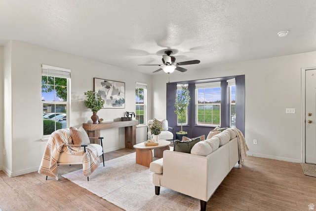 1041 South 1850th Street West Springville, UT 84663 - Photo 5 of 35 Wood-finish flooring, multiple windows, ceiling fan with integrated lighting, and a bay window feature in this living area