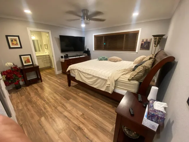 a bed room with a bed a television and a large window