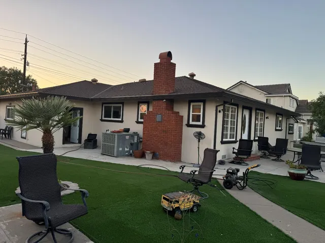 a living room with couches chairs and a dining table with kitchen view
