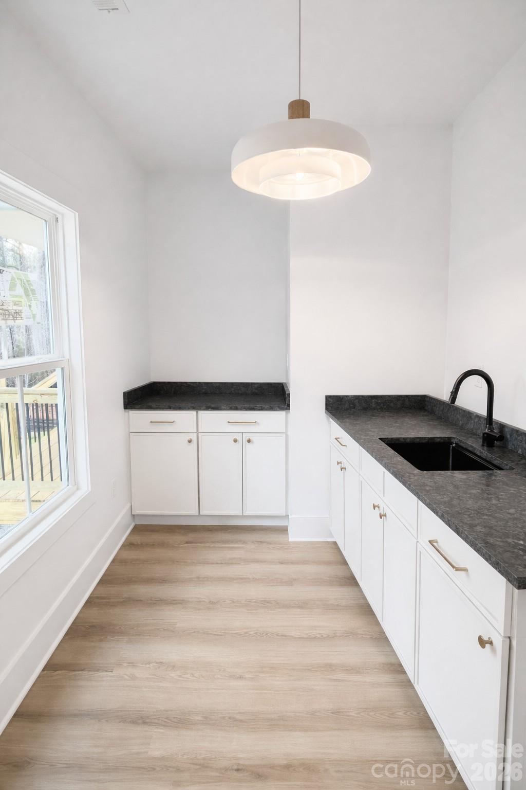 5135 Star Magnolia Court Clover, SC 29710 - Photo 17 of 39 a kitchen with granite countertop a sink and a white wooden cabinets