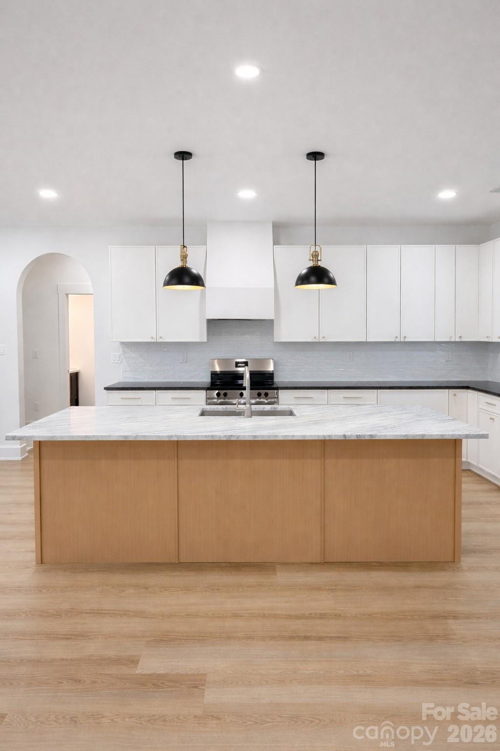 5135 Star Magnolia Court Clover, SC 29710 - Photo 19 of 39 a large kitchen with granite countertop a stove a sink a center island and cabinets