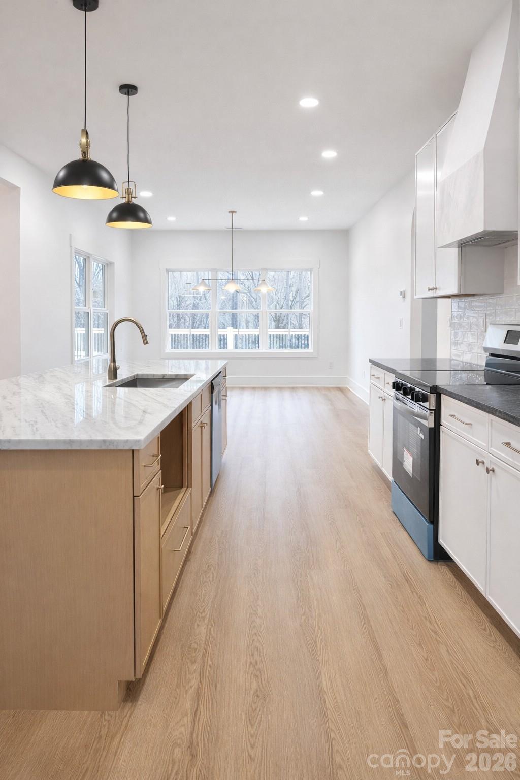 5135 Star Magnolia Court Clover, SC 29710 - Photo 7 of 39 a kitchen with stainless steel appliances granite countertop a sink a stove and a wooden floors