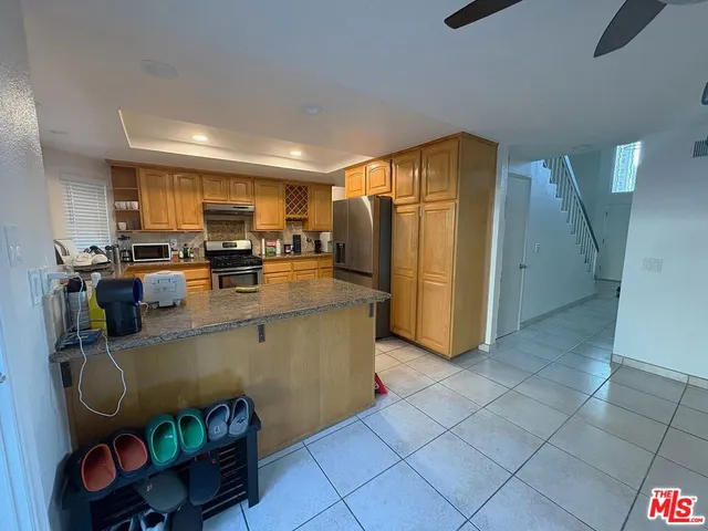 a kitchen with stainless steel appliances granite countertop a refrigerator a sink a stove and a microwave oven