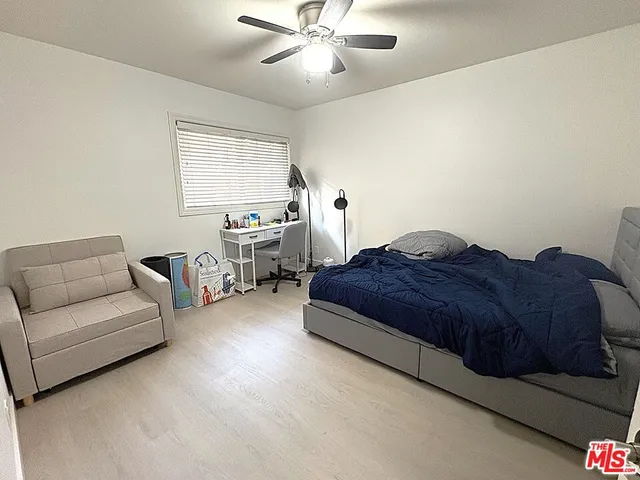 a spacious bedroom with a bed couches and chandelier