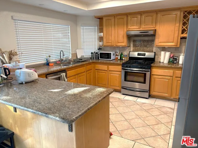 a kitchen with stainless steel appliances granite countertop a sink and a counter