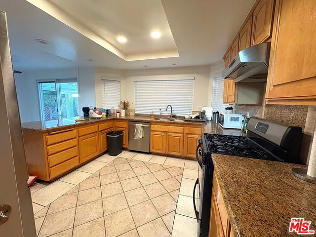 a kitchen with stainless steel appliances a sink a stove top oven a counter space and cabinets