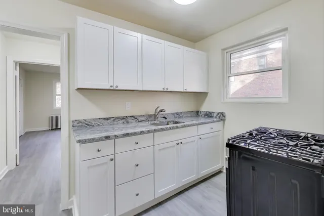 a kitchen with granite countertop cabinets stainless steel appliances a sink and a window
