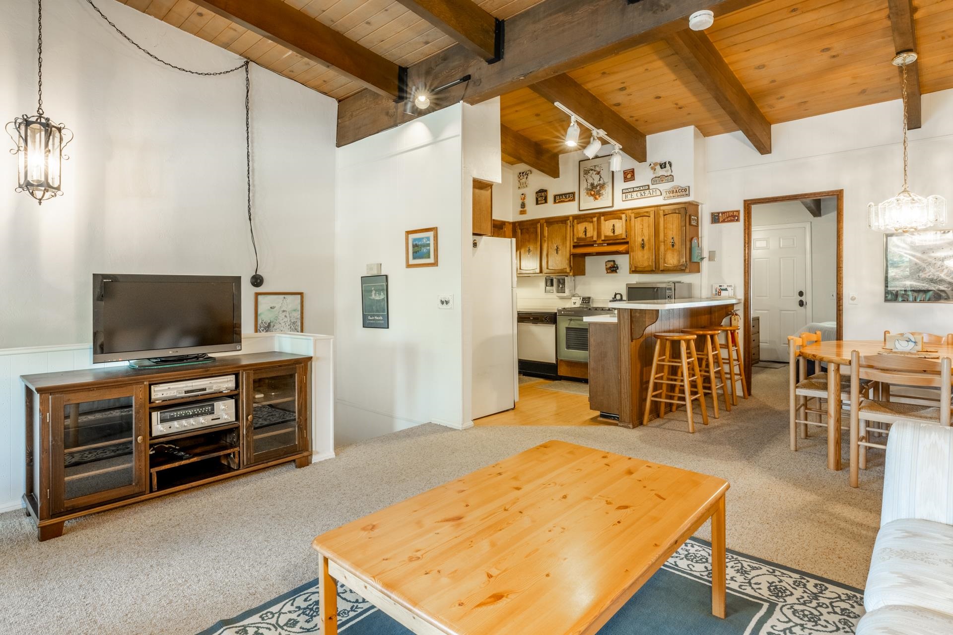 50 Hidden Valley Road, Unit 17 Mammoth Lakes, CA 93546 - Photo 7 of 40 Living area featuring a beamed ceiling, carpet flooring, and a decorative pendant light fixture