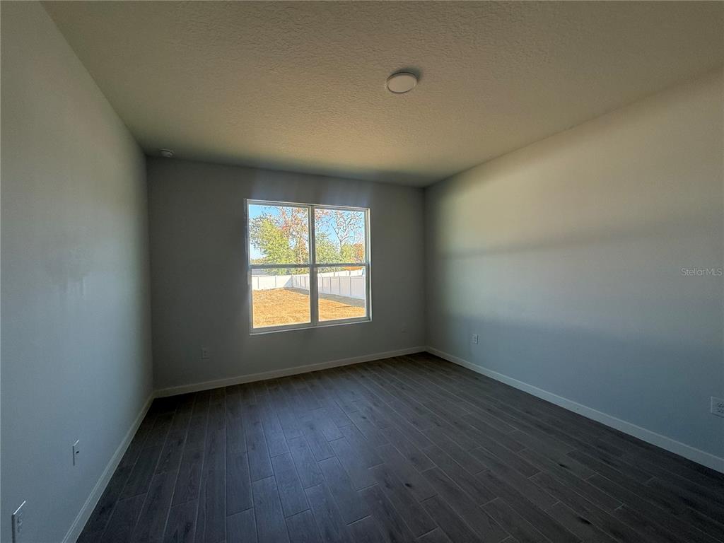 76 Boston Lane Palm Coast, FL 32137 - Photo 6 of 15 an empty room with wooden floor and windows