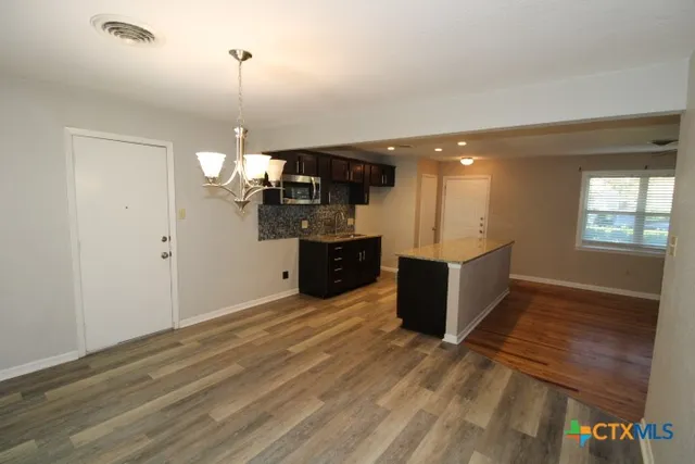 a view of a kitchen with granite countertop a stove and a wooden floor