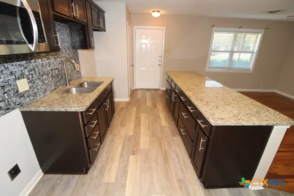 a kitchen with a sink stove and cabinets