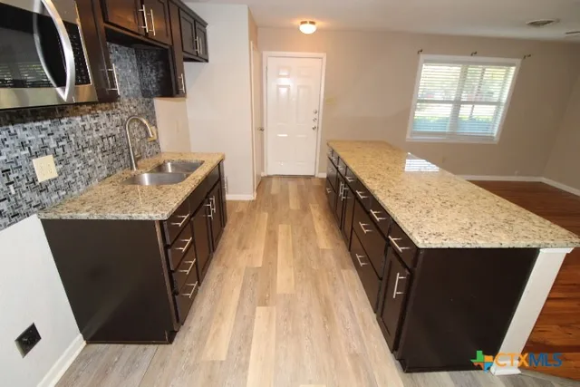 a kitchen with a sink stove and cabinets