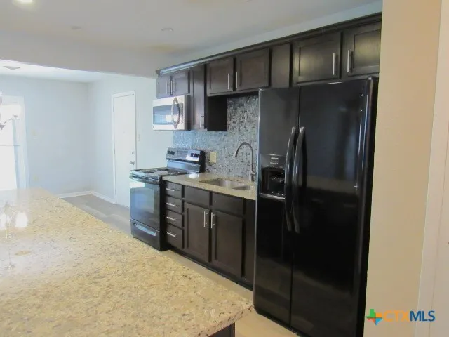 a kitchen with a sink stainless steel appliances and cabinets