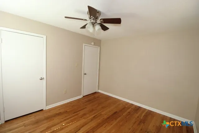a view of empty room with wooden floor