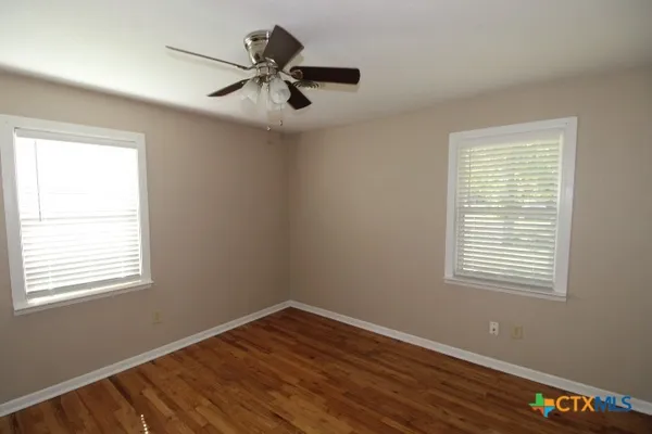 a view of a room with wooden floor and windows
