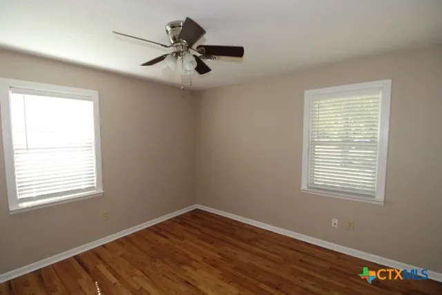a view of a room with wooden floor and windows