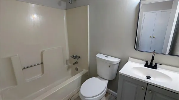 a white toilet sitting next to a bath tub