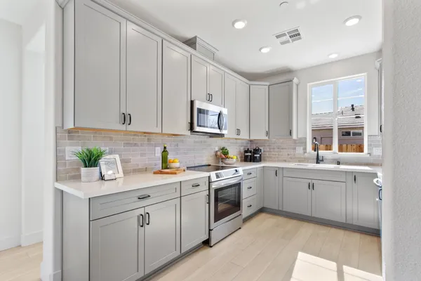 a kitchen with a sink white cabinets and white appliances