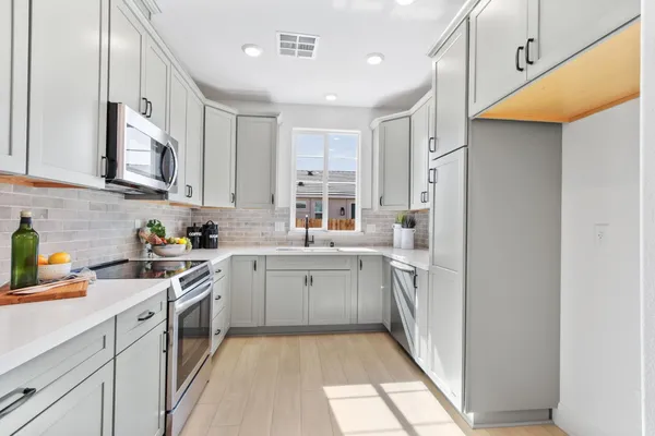 a kitchen with white cabinets and white appliances