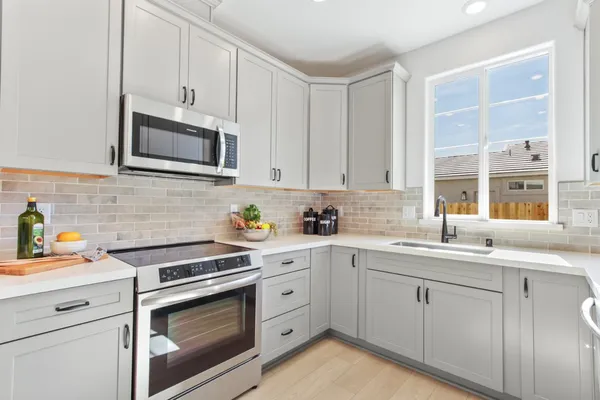 a kitchen with cabinets stainless steel appliances a sink and a window