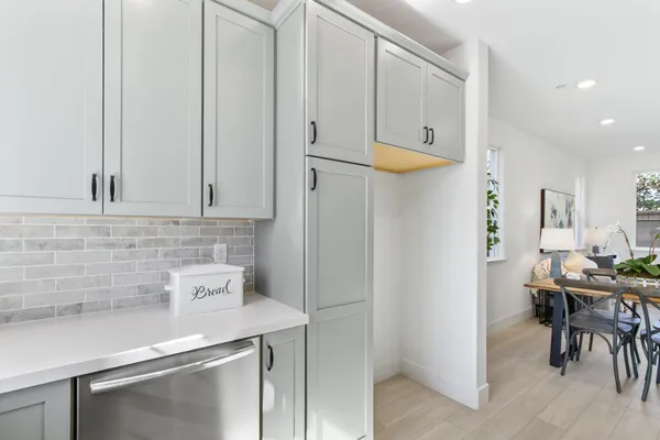 a kitchen with stainless steel appliances white cabinets and a refrigerator