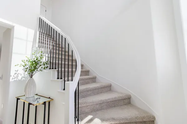 a view of staircase with railing and white walls