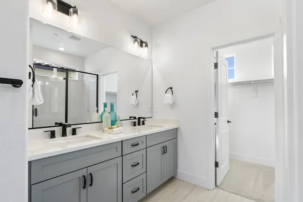a bathroom with double sink and a mirror
