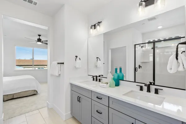 a bathroom with a double vanity sink a mirror and a shower