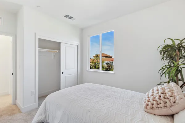a bedroom with a bed and a painting on the wall