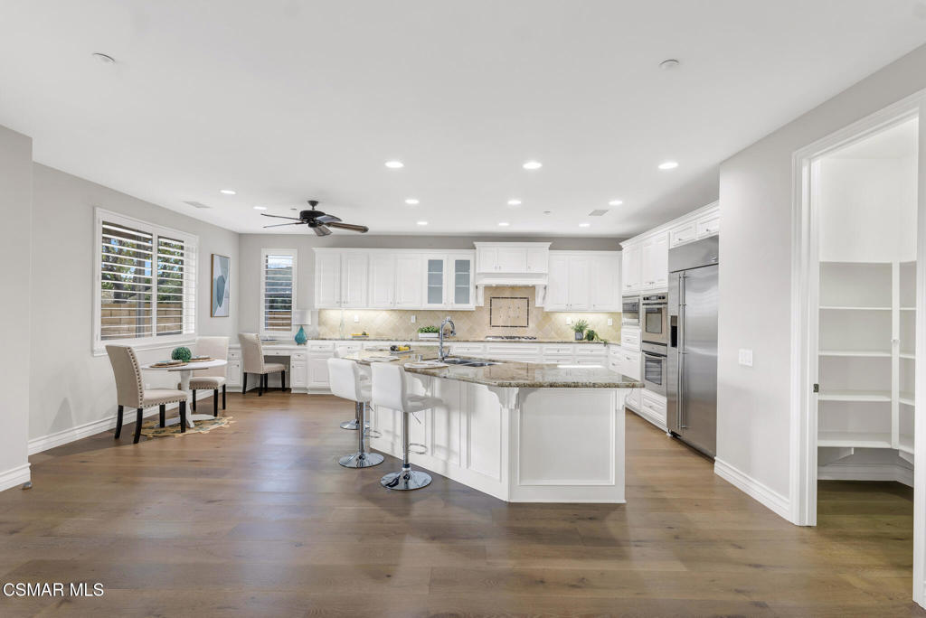 3421 Deep Waters Court Simi Valley, CA 93065 - Photo 24 of 74 a kitchen with stainless steel appliances kitchen island granite countertop a table chairs sink and cabinets