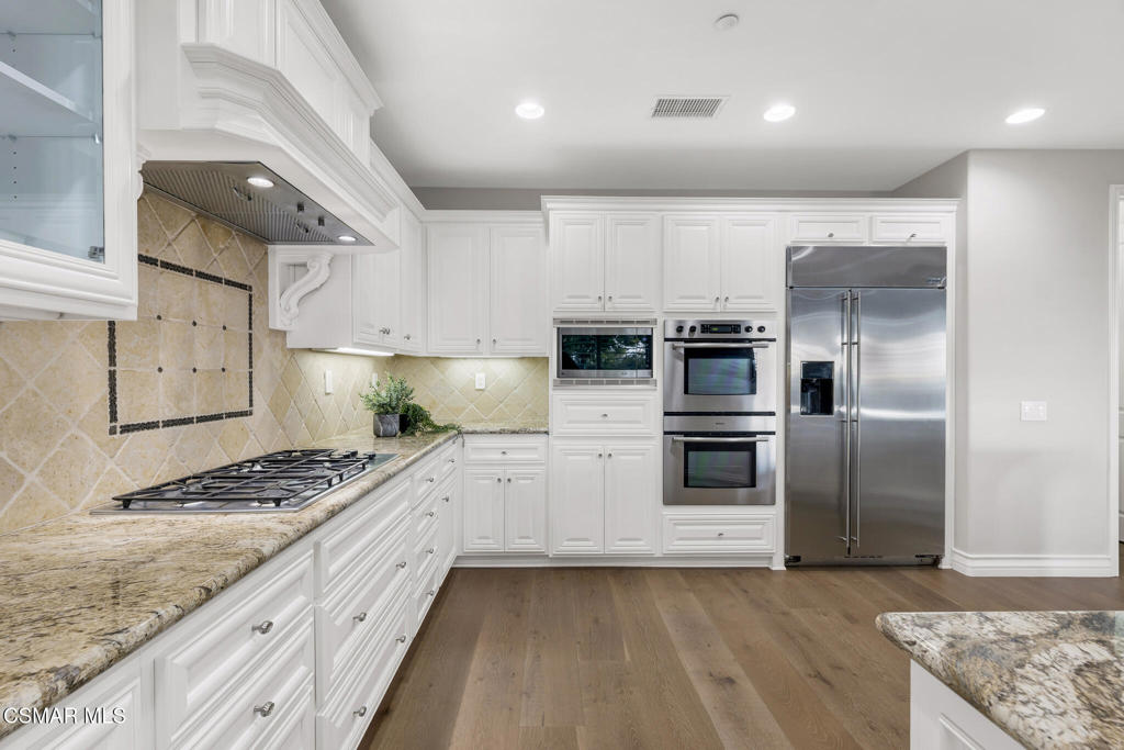 3421 Deep Waters Court Simi Valley, CA 93065 - Photo 29 of 74 a kitchen with stainless steel appliances kitchen island granite countertop a stove and a refrigerator