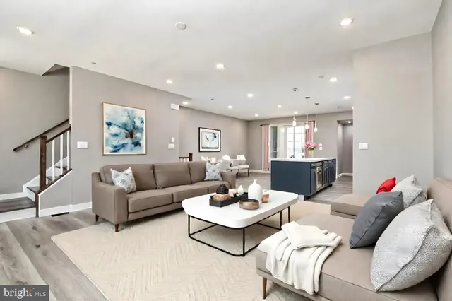 a living room with furniture and a dining table with wooden floor