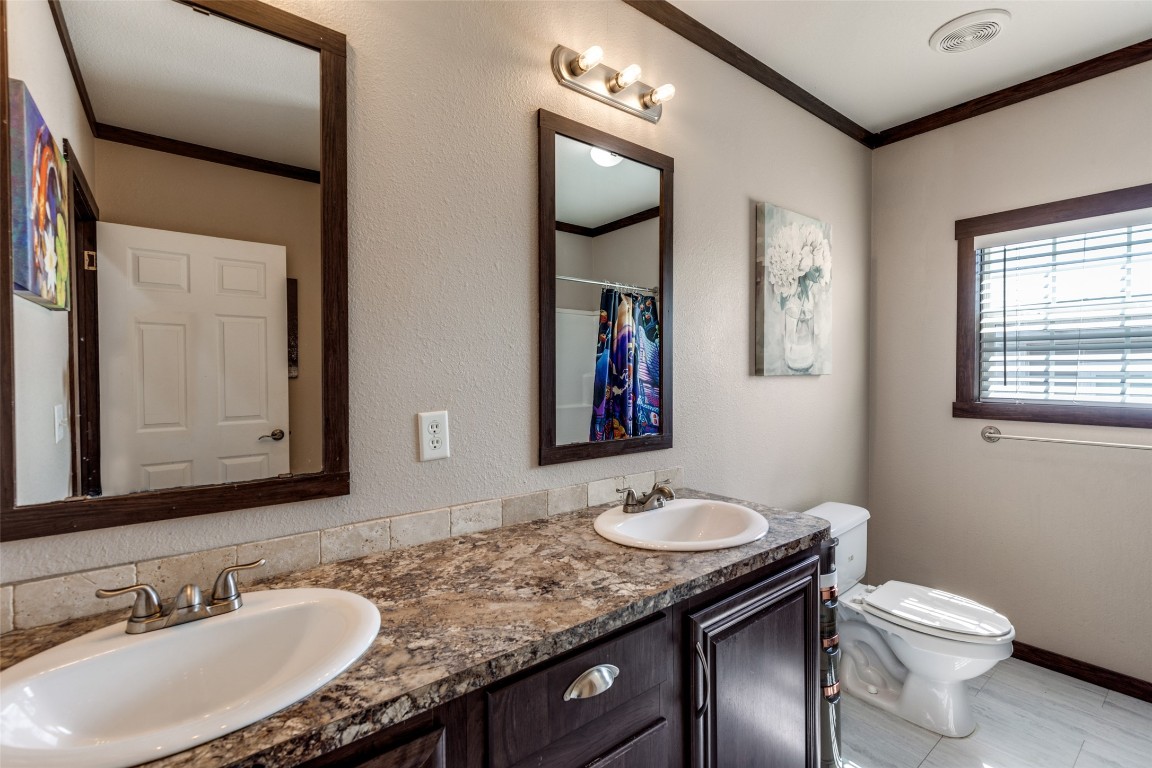 7905 Plato Path, Unit 111 Austin, TX 78724 - Photo 11 of 12 a bathroom with a granite countertop sink vanity mirror and toilet