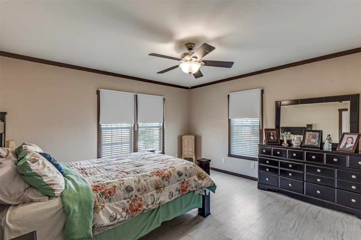 7905 Plato Path, Unit 111 Austin, TX 78724 - Photo 7 of 12 a spacious bedroom with a bed a dresser and a chandelier