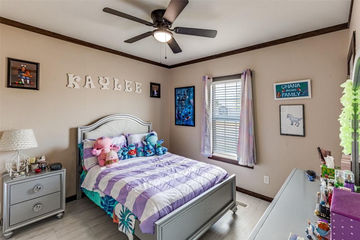 7905 Plato Path, Unit 111 Austin, TX 78724 - Photo 9 of 12 a bedroom with a large bed and a chandelier fan