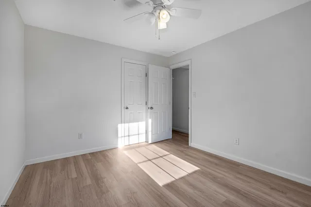 an empty room with a window and wooden floor