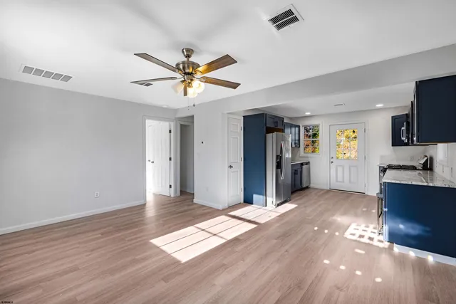 a kitchen with stainless steel appliances granite countertop a refrigerator and a stove top oven