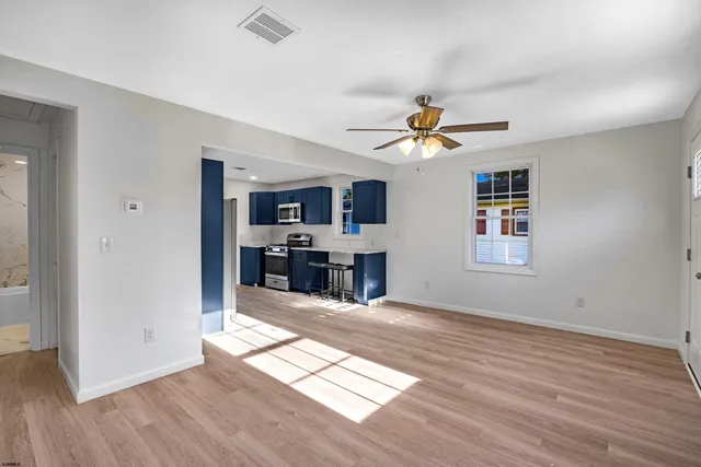 a kitchen with stainless steel appliances a stove a sink a microwave and wooden cabinets
