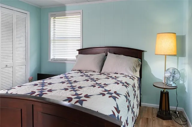 a bedroom with a bed and a lamp next to a window