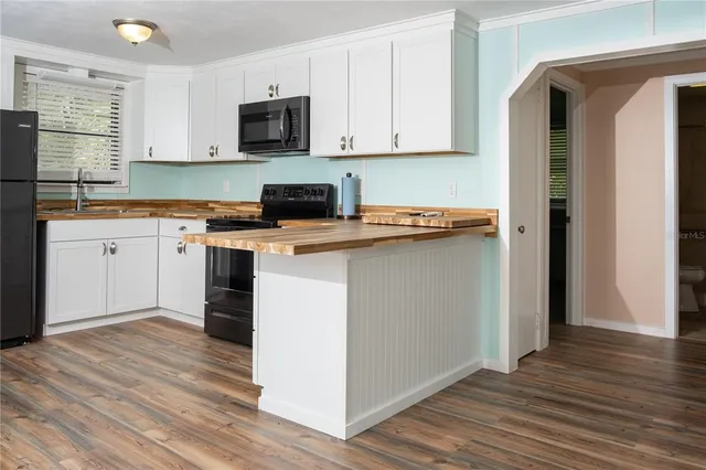 a kitchen with a sink cabinets and wooden floor