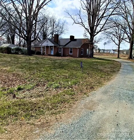 a front view of house with yard and trees around