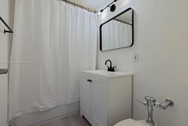 a bathroom with a sink a mirror and shower curtain