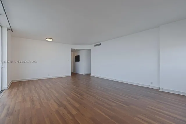 a view of an empty room and wooden floor