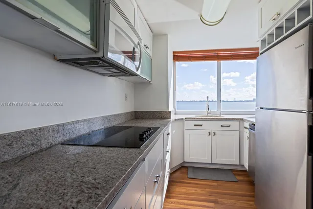 a kitchen with a granite countertop sink and cabinets