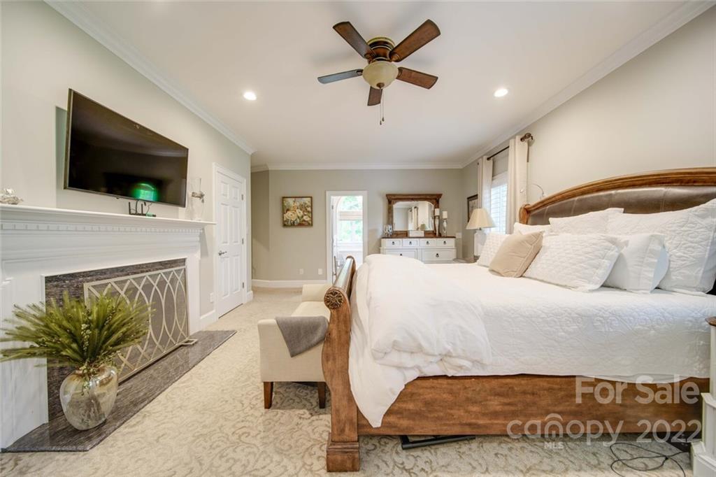 3617 Lake Twitty Drive Monroe, NC 28110 - Photo 33 of 47 a spacious bedroom with a bed a couch and a flat screen tv