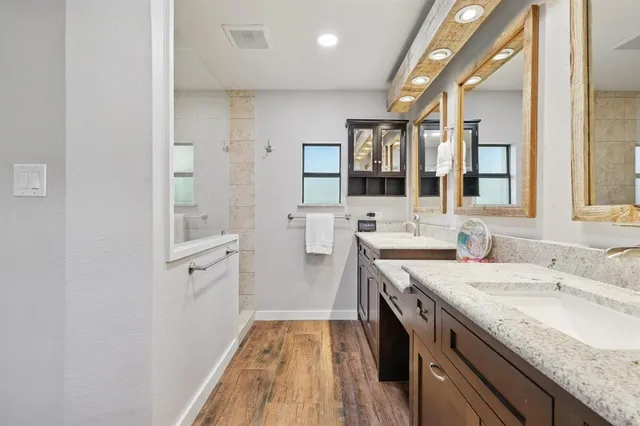 a spacious bathroom with a granite countertop sink mirror and