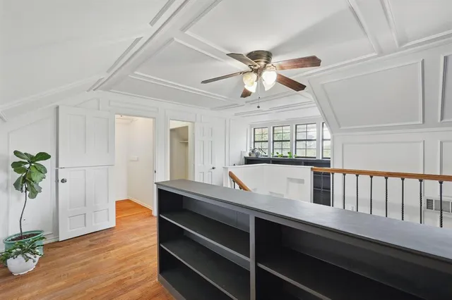 a dining room with wooden floor a chandelier a glass table and chairs