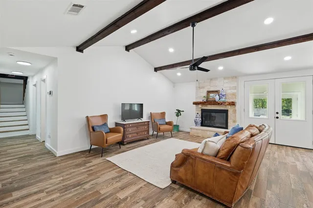 a living room with furniture a fireplace and a flat screen tv