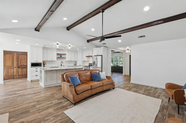 a living room with stainless steel appliances kitchen island granite countertop furniture and a kitchen view